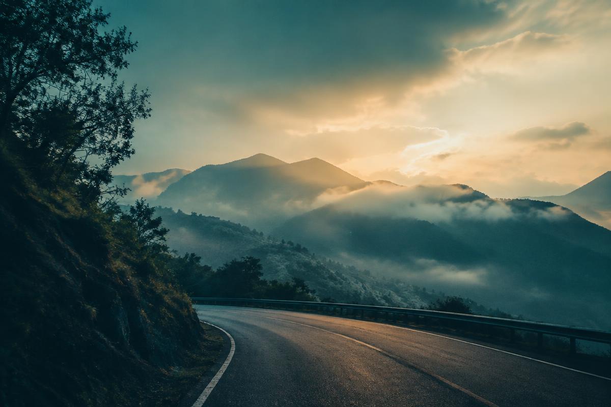 A misty mountain road at dawn